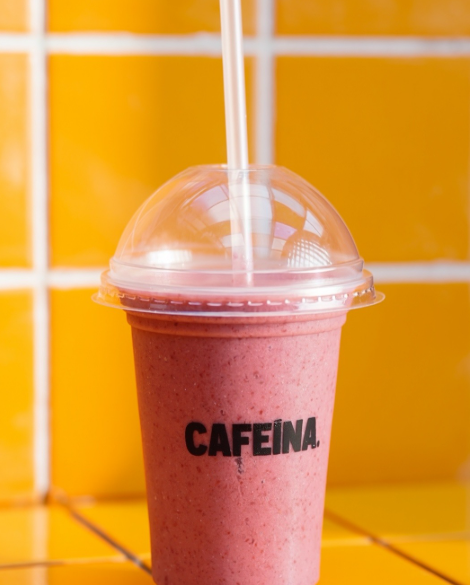 Bebida rosa em um copo Cafeína, diante do balcão laranja