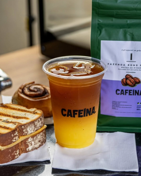 Café gelado da Cafeína com sanduíche, doce e embalagem de grãos
