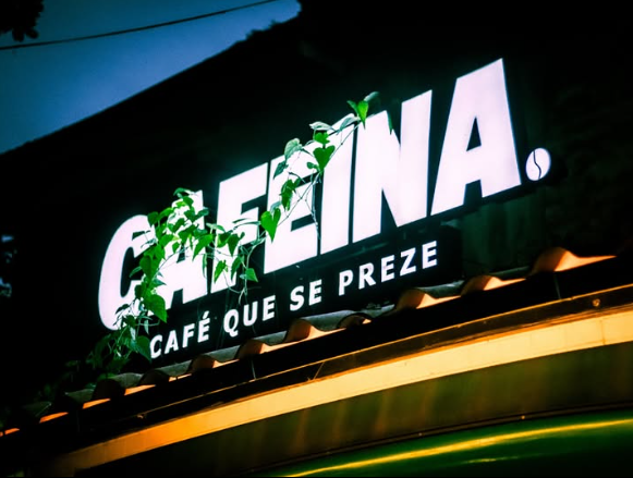 Fachada iluminada da Cafeína com a frase Café que se preze